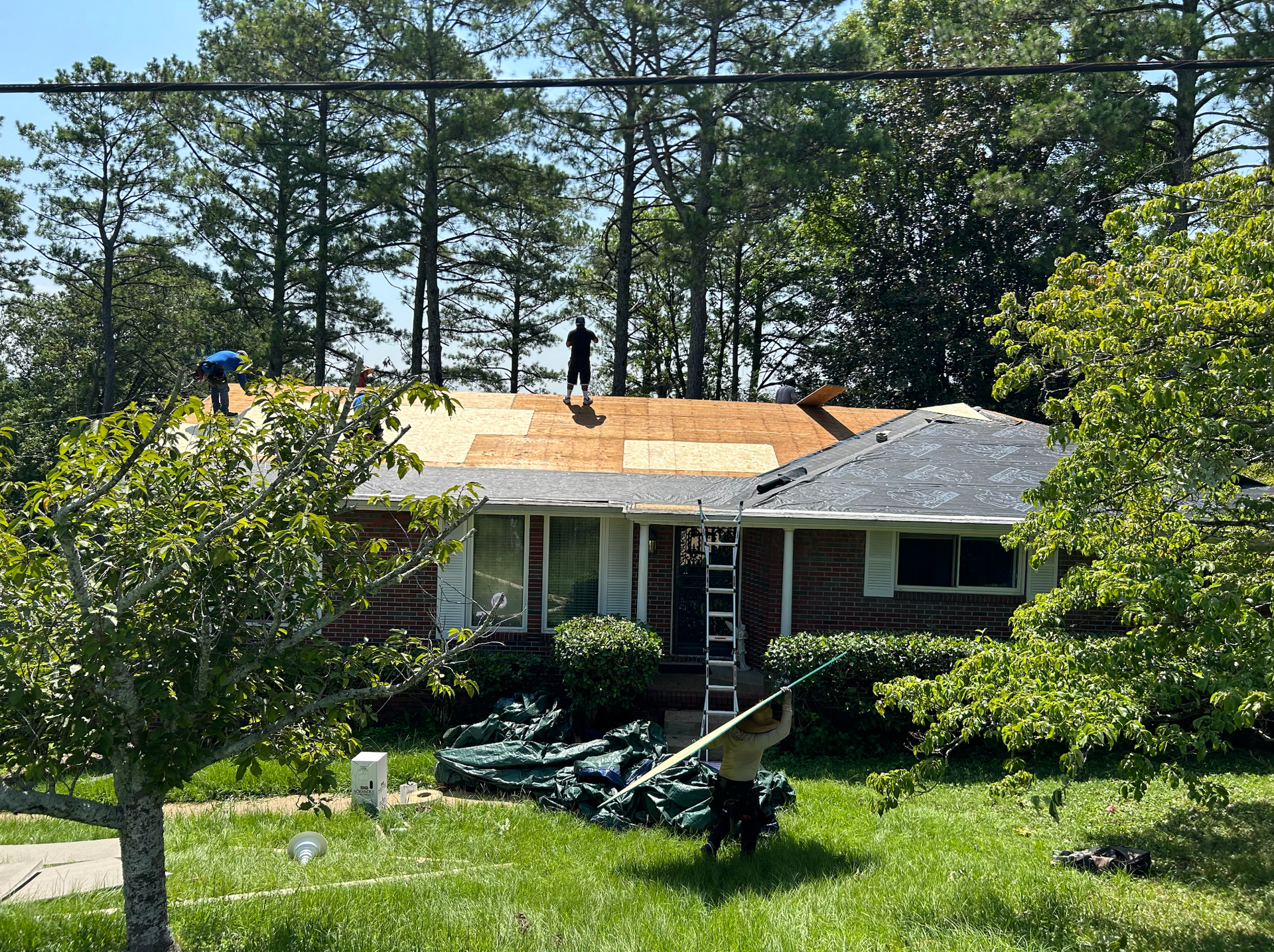 Two men are working on the roof of a house.