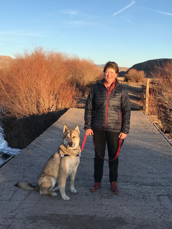 kathleen fogo with dog on leash standing on trail