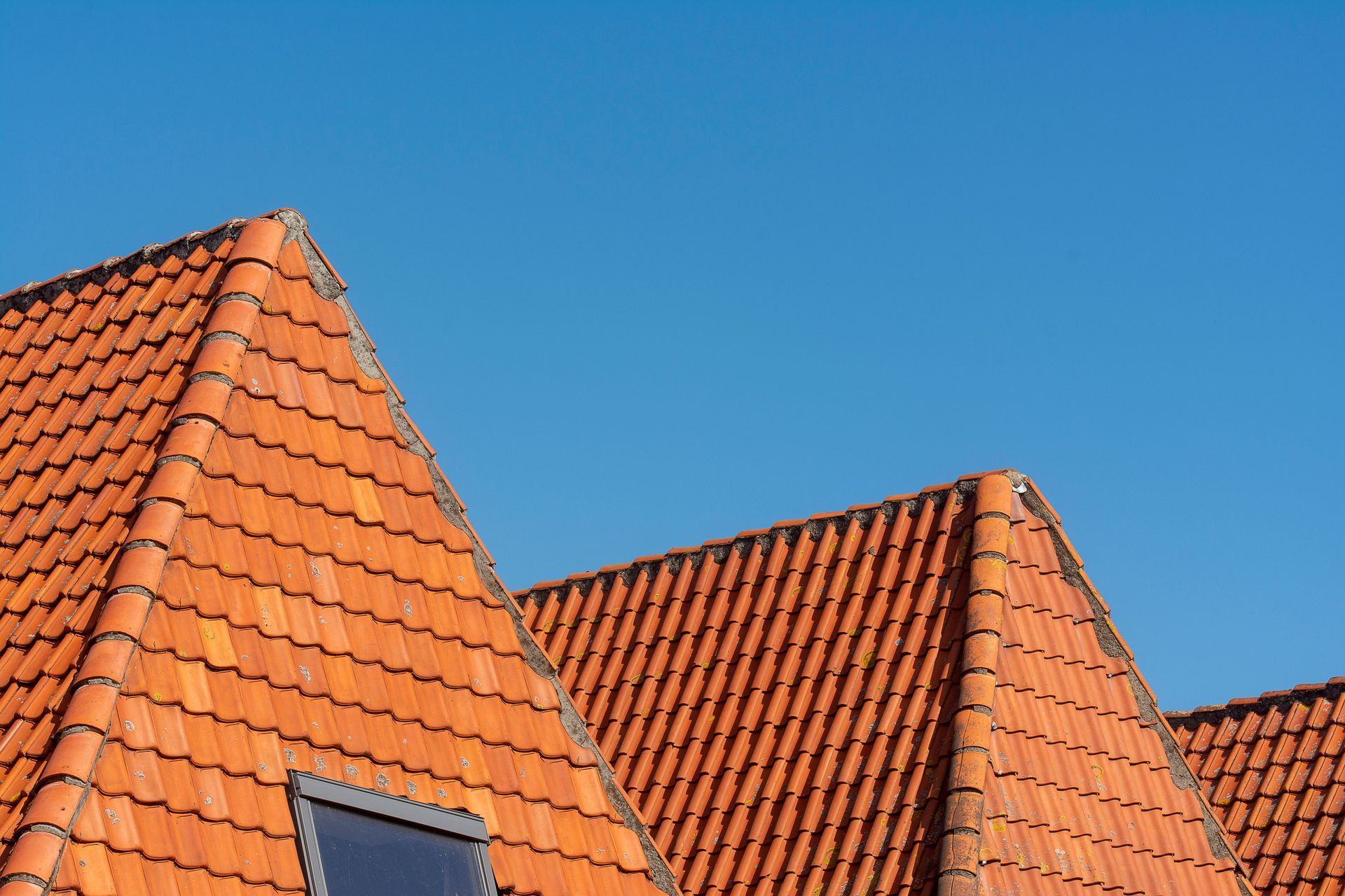 Orange tiled rooftops against a clear blue sky