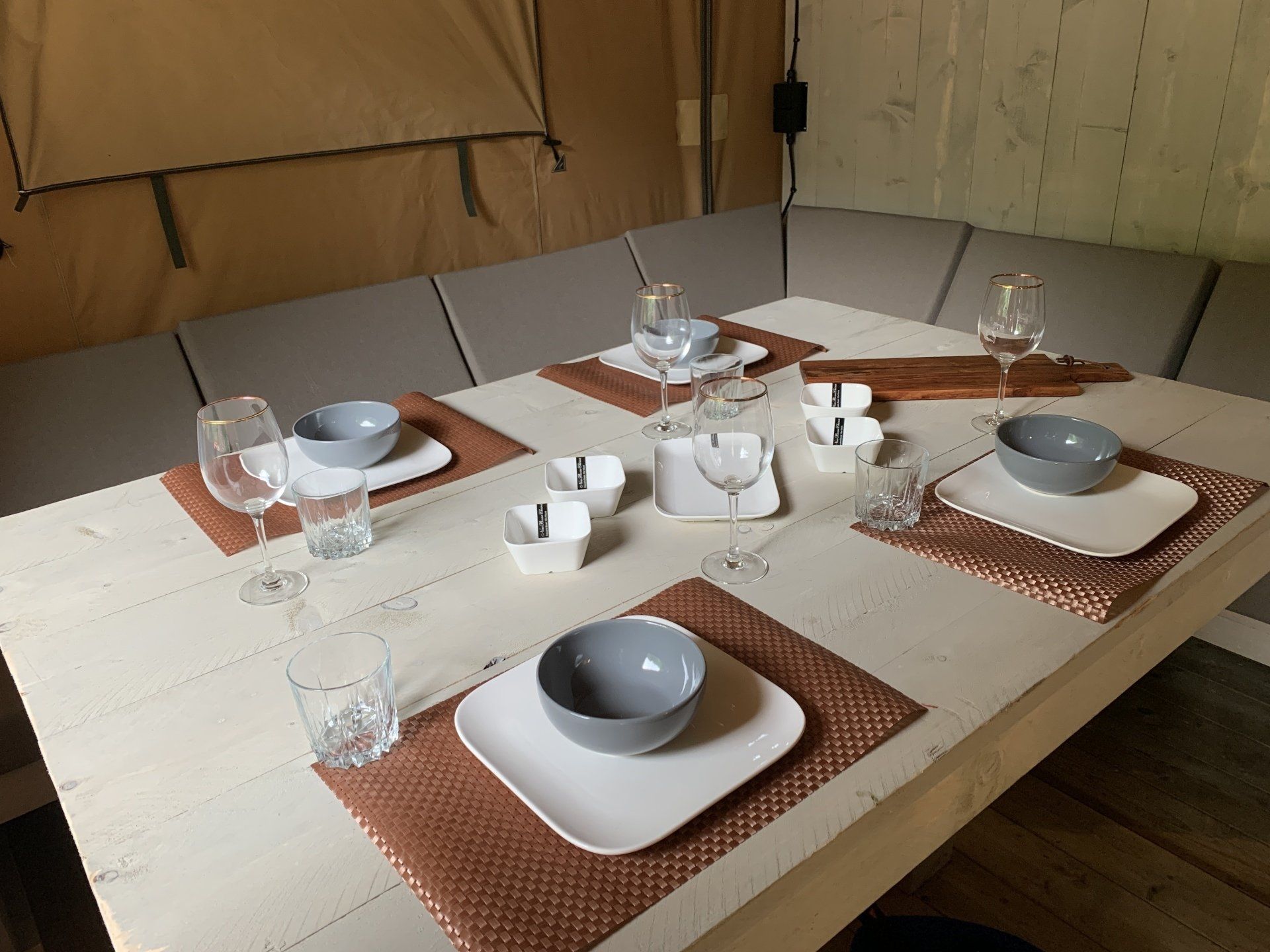 Een tafel met borden, kommen en glazen erop