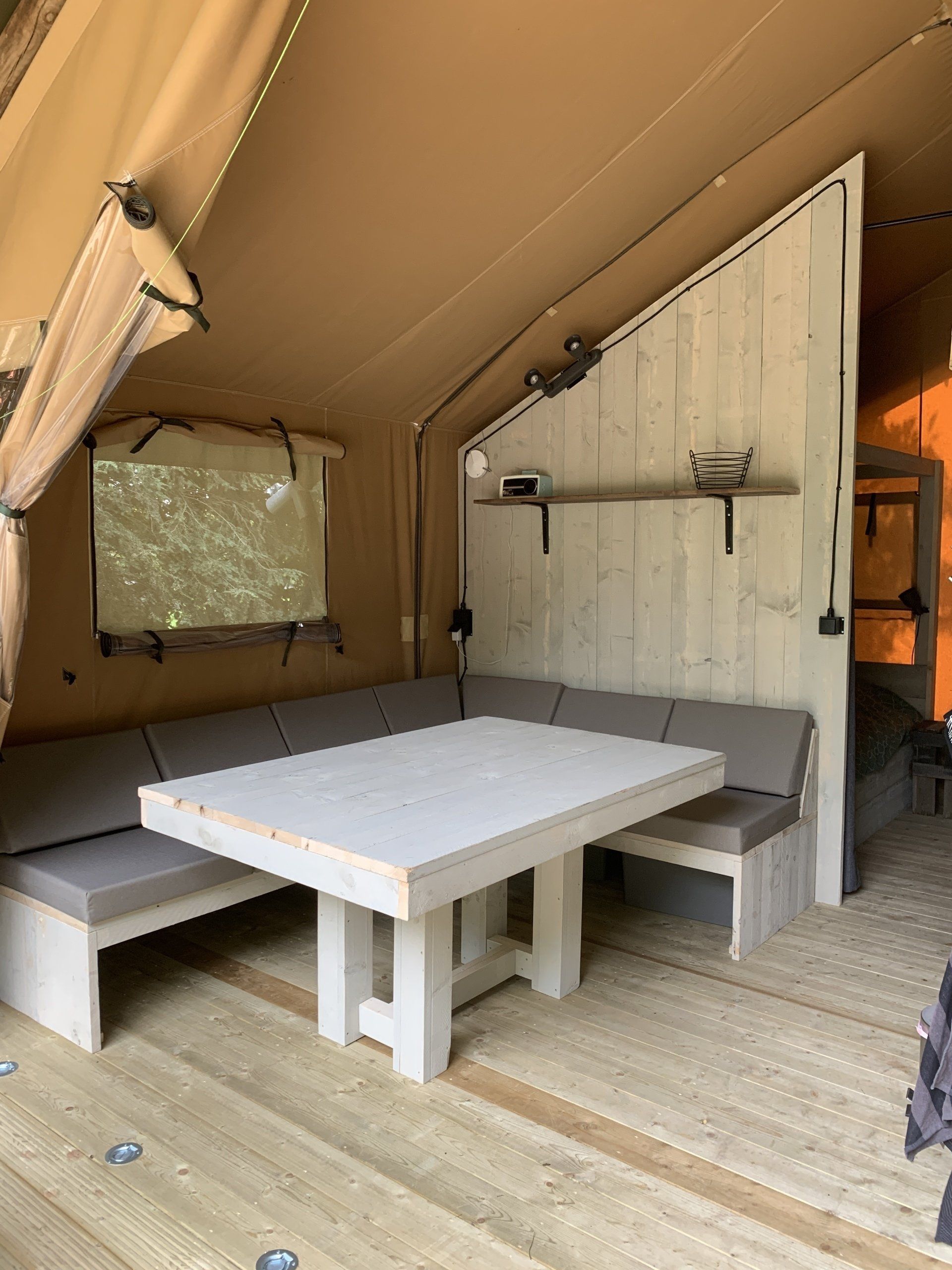 Er staat een tafel en een bank in de kamer.