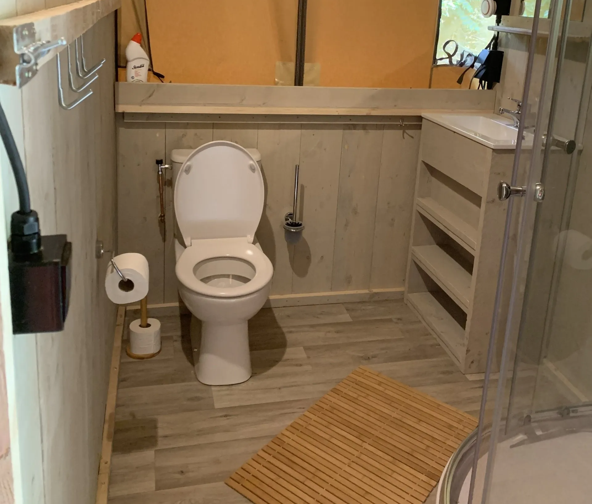 Een badkamer met toilet, wastafel en douche.