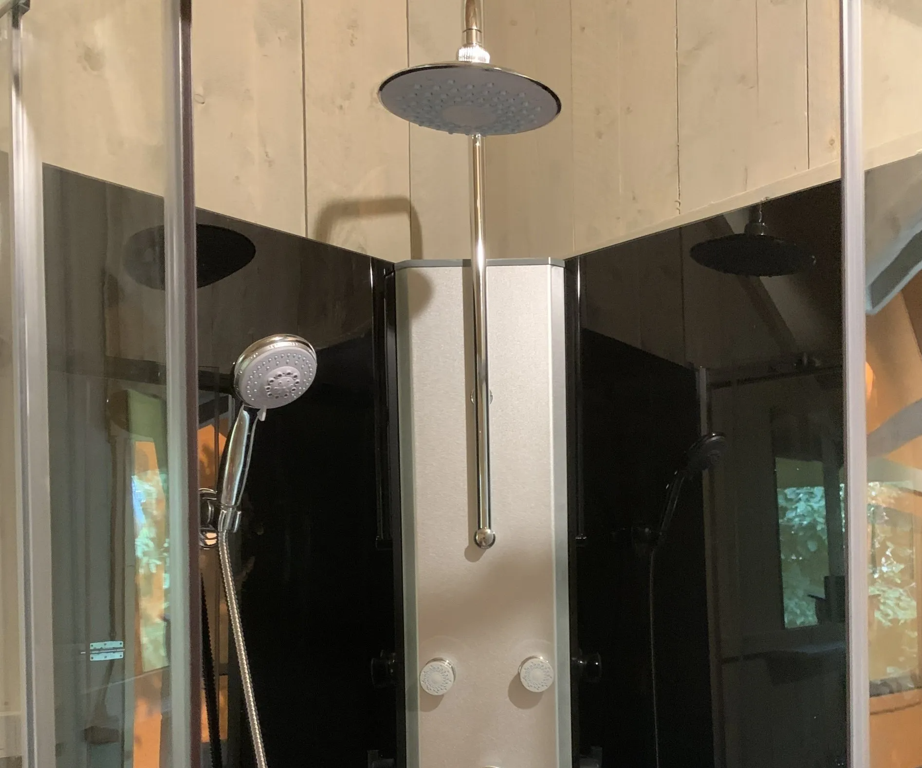 Een douchecabine met een douchekop die aan het plafond hangt