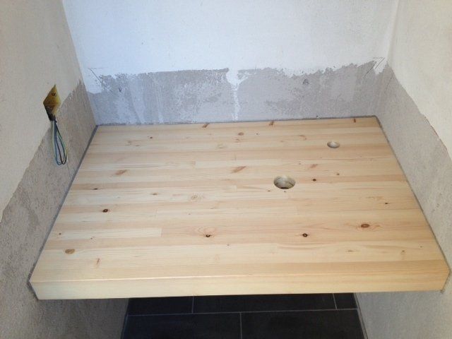 tavolo di legno appoggiato su un pavimento piastrellato.