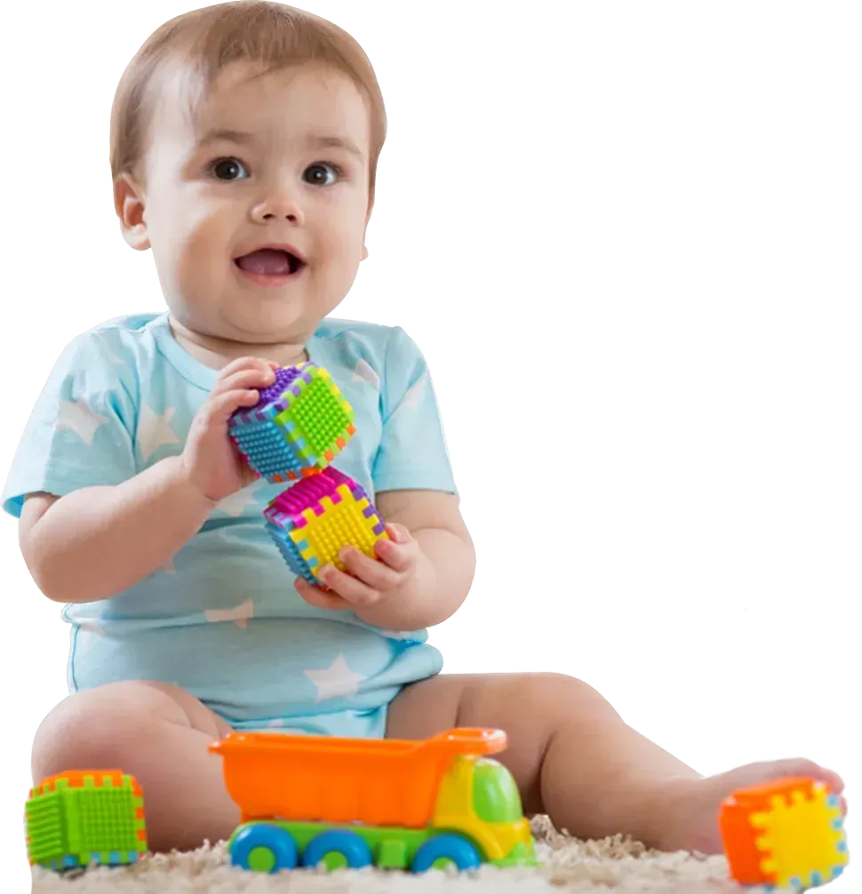 Baby in a light blue outfit sitting with colorful toy blocks and a toy car on a white background