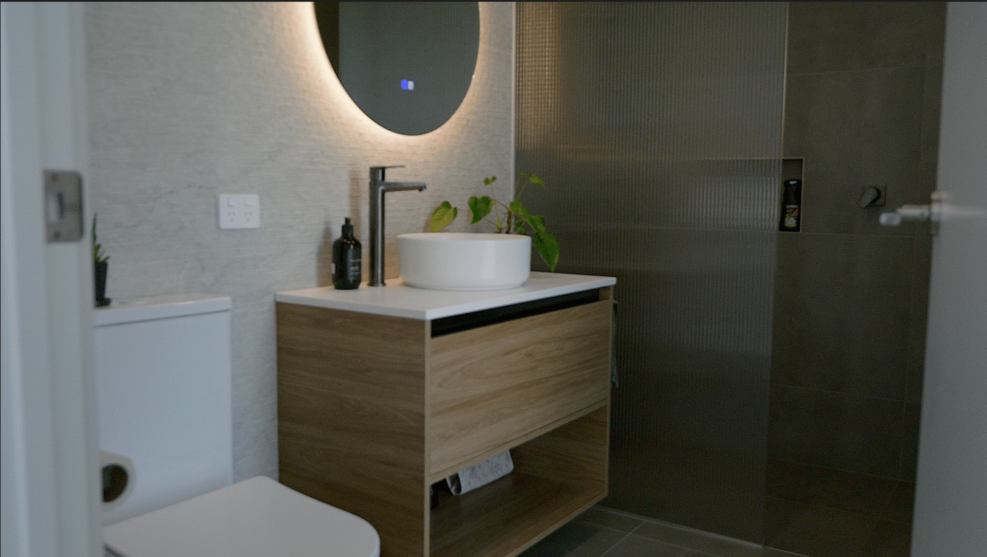 Modern two-story house with a brown wood facade, black garage, and concrete driveway.