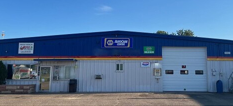 A blue auto repair shop with an open garage door, under a clear sky. | King's Auto Care Center