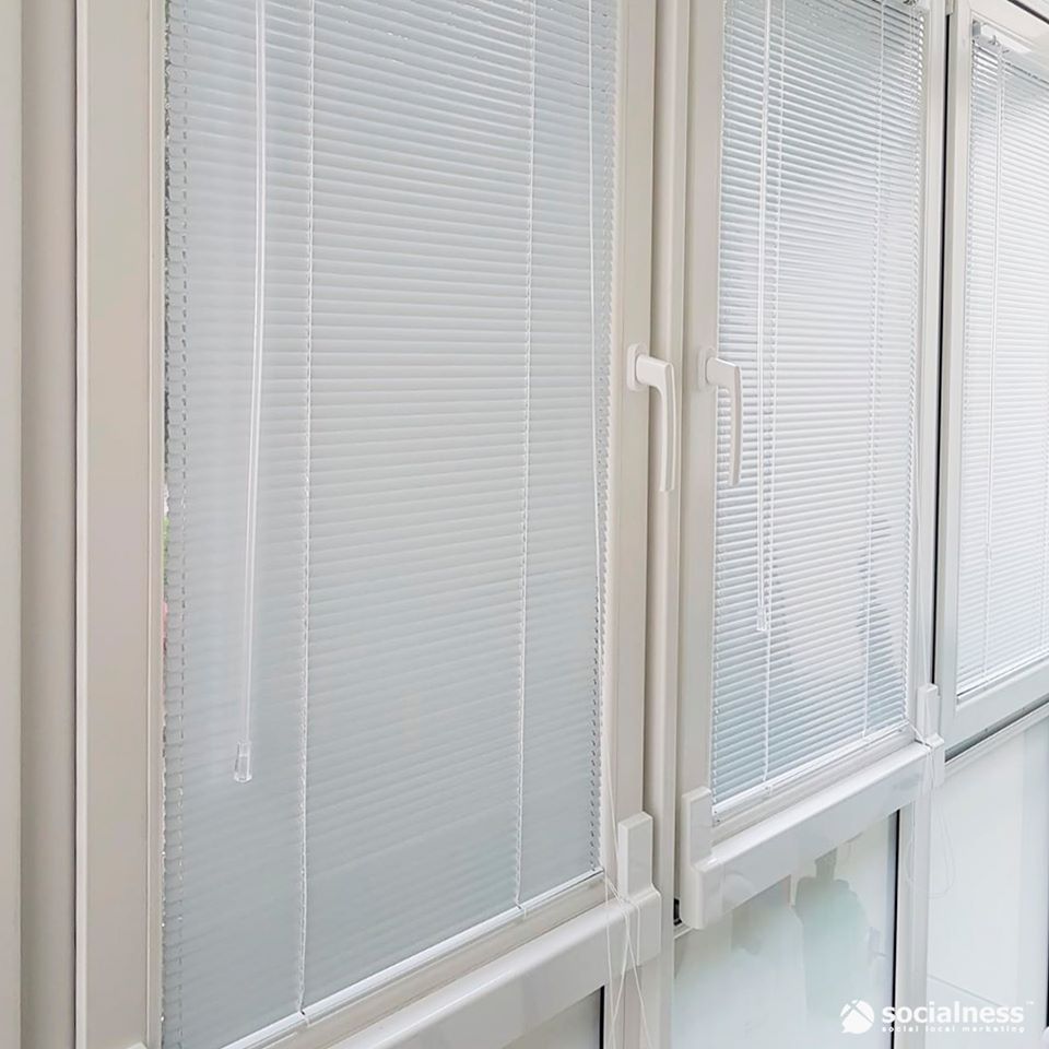 Tende bianche su più finestre rettangolari.