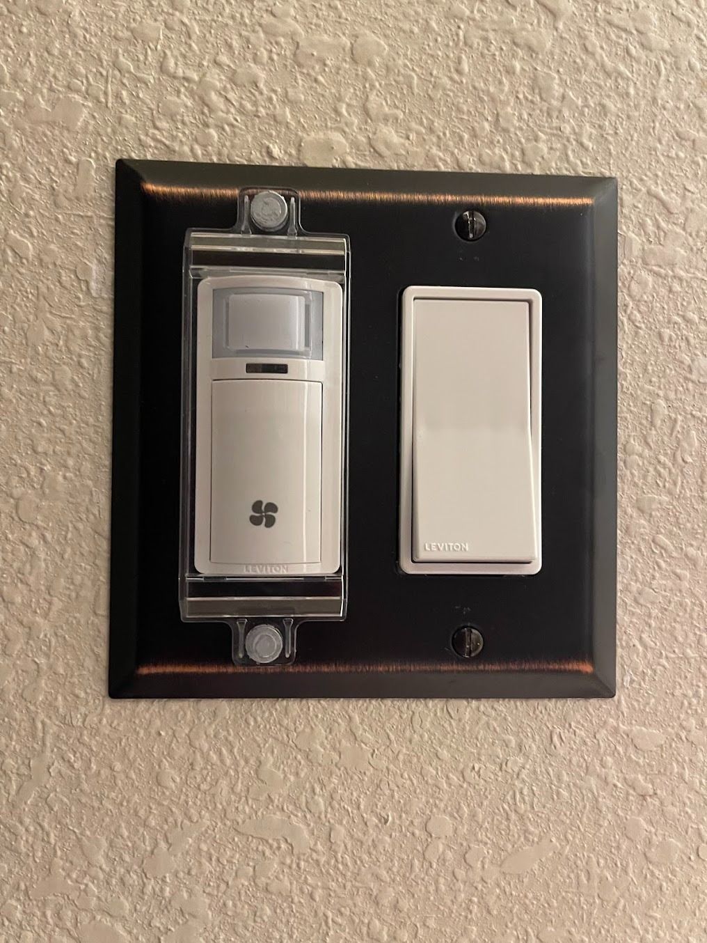 Wall switch plate with a smart switch on the left and a blank white rocker on the right.