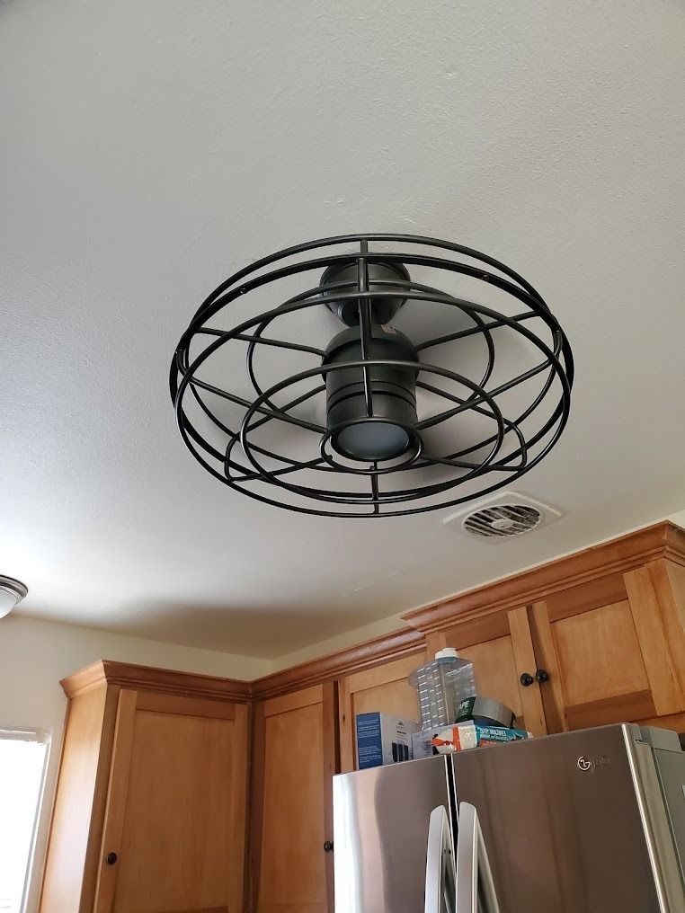 Ceiling fan in a kitchen with wooden cabinets and a stainless steel refrigerator