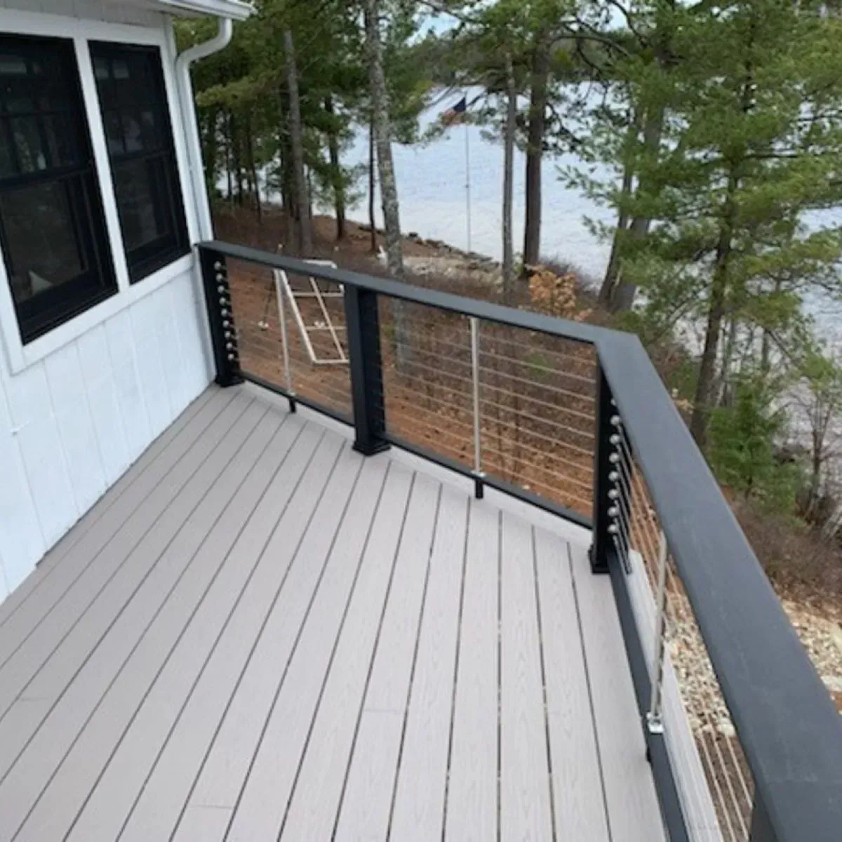 A deck with a view of a lake and trees