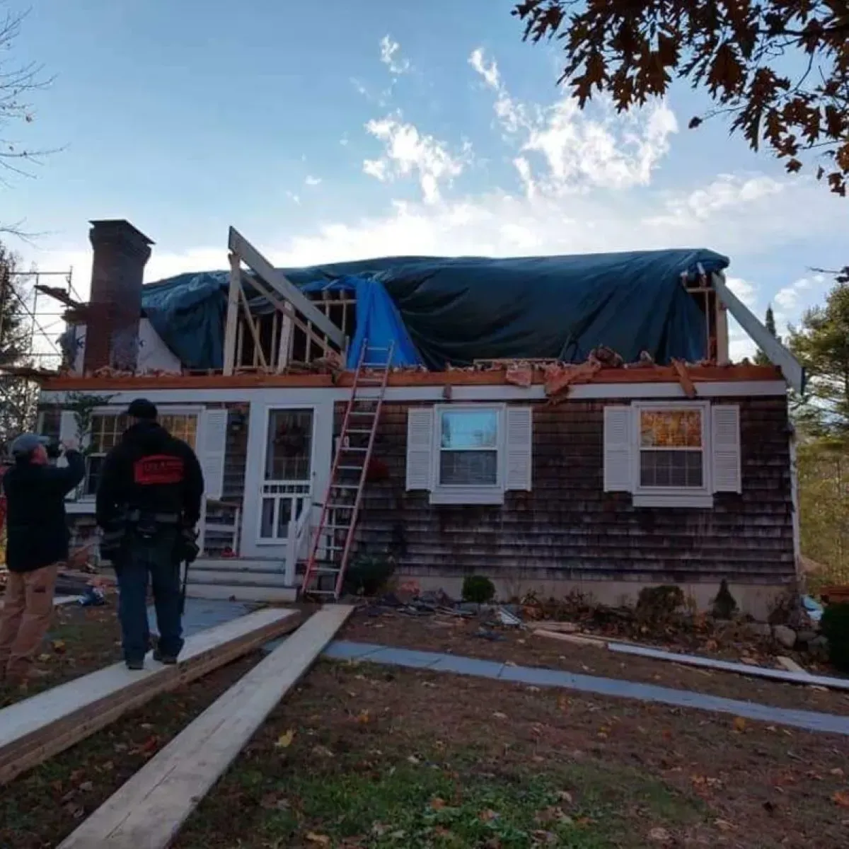 A house under construction with a tarp on the roof
