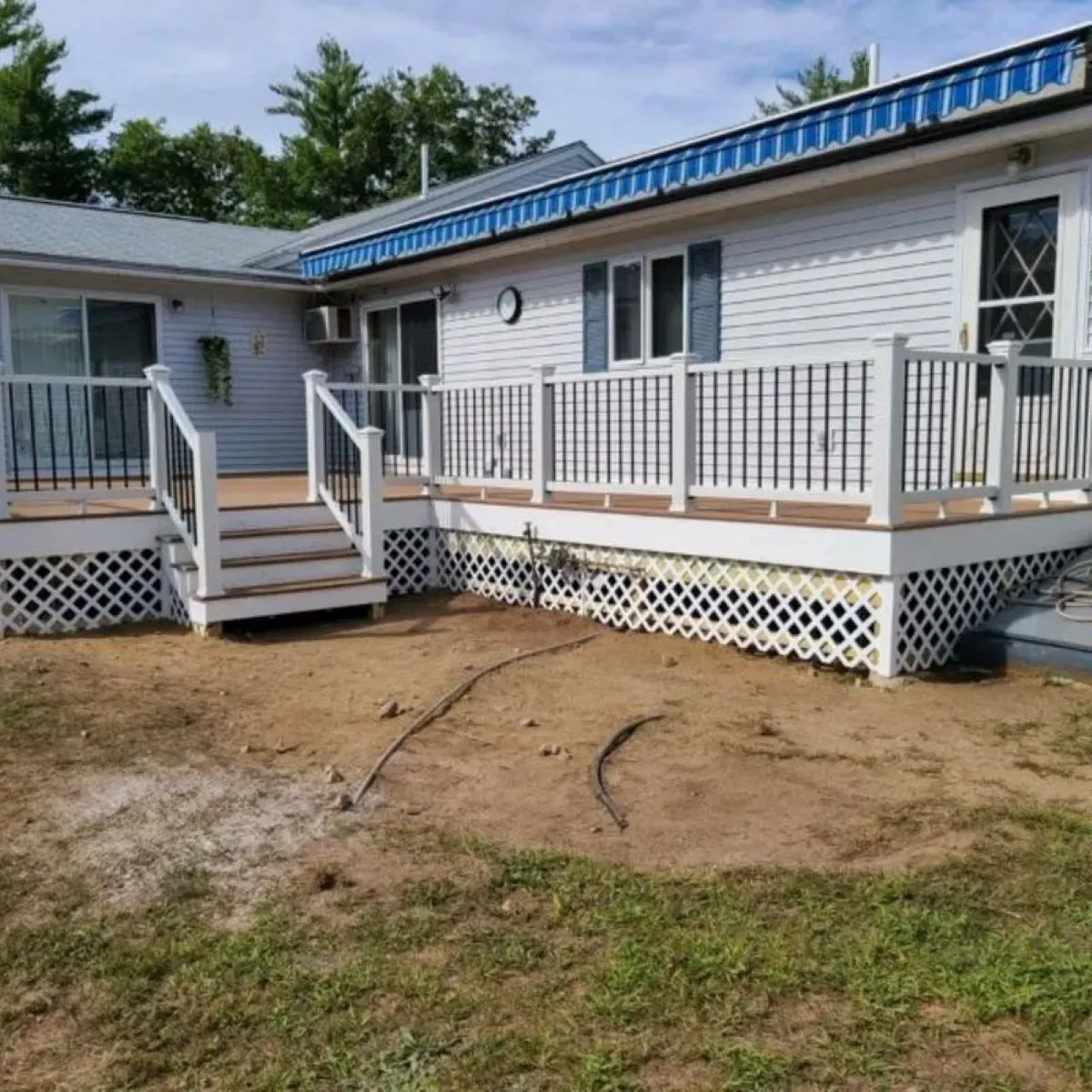 A white house with a large deck and stairs
