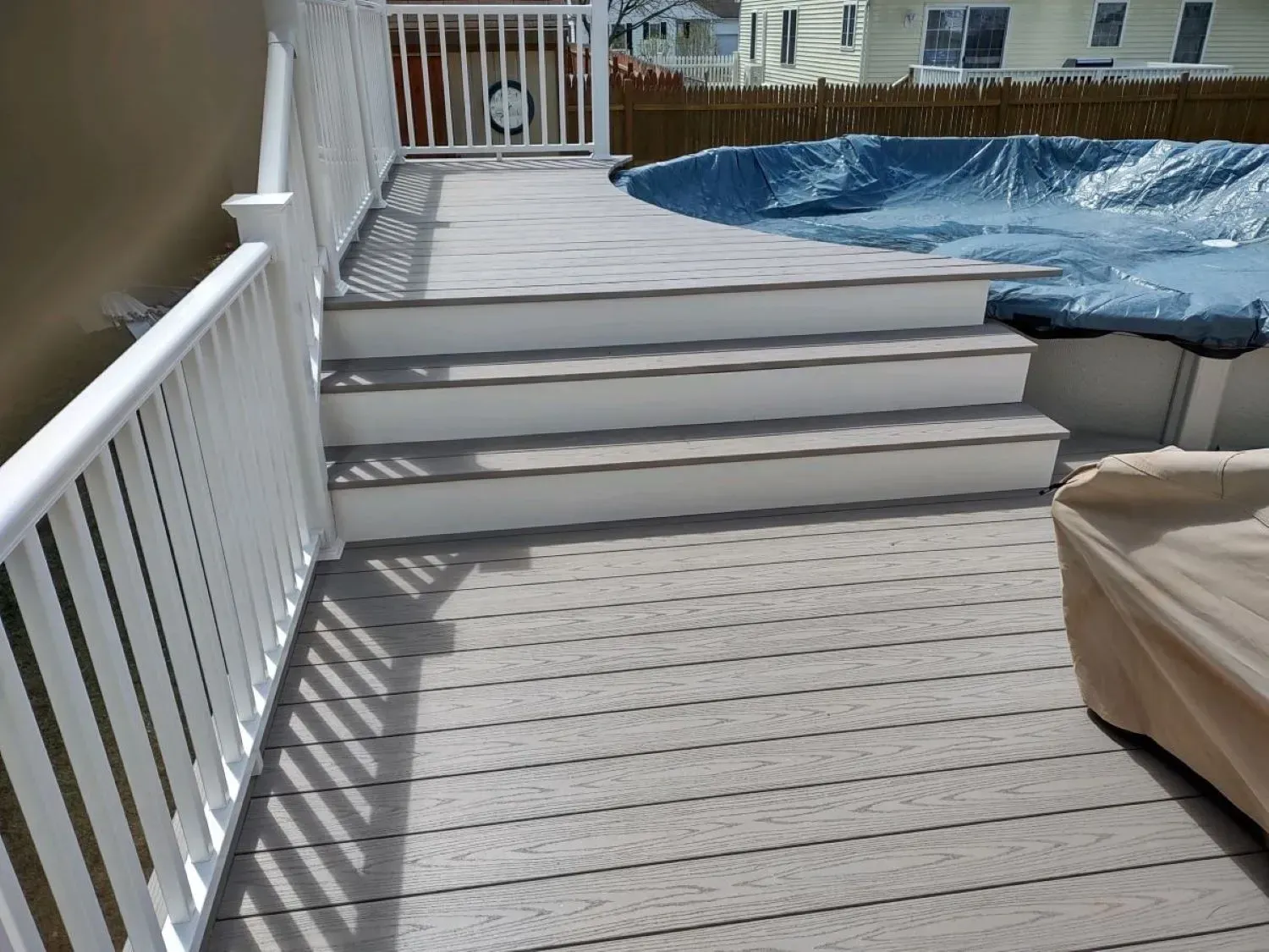 A deck with stairs leading up to a hot tub