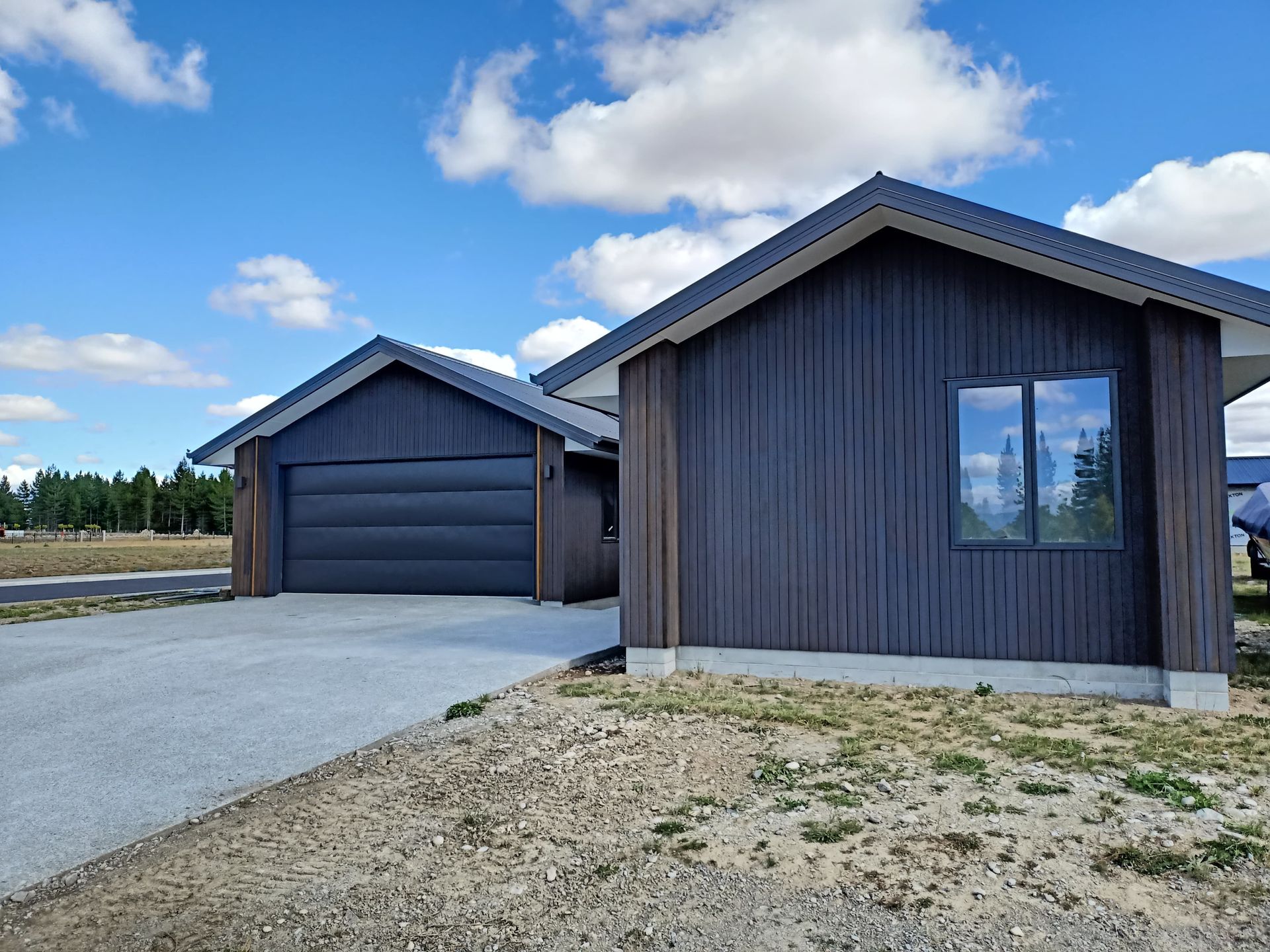 A house with a garage and a driveway in front of it.