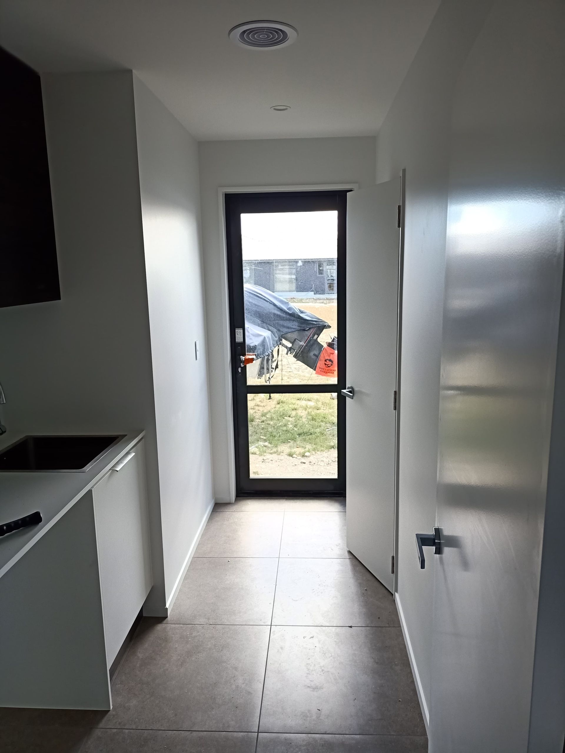 A long hallway with a door and a window in a kitchen.