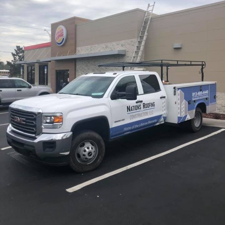 A blue and grey wrap on the white Nations vehicle shows phone number 813-485-4440.