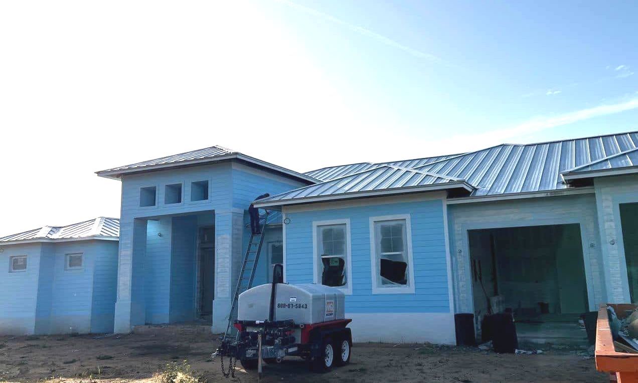 Silver metal roof on new home construction installed by Nations Roofing & Construction