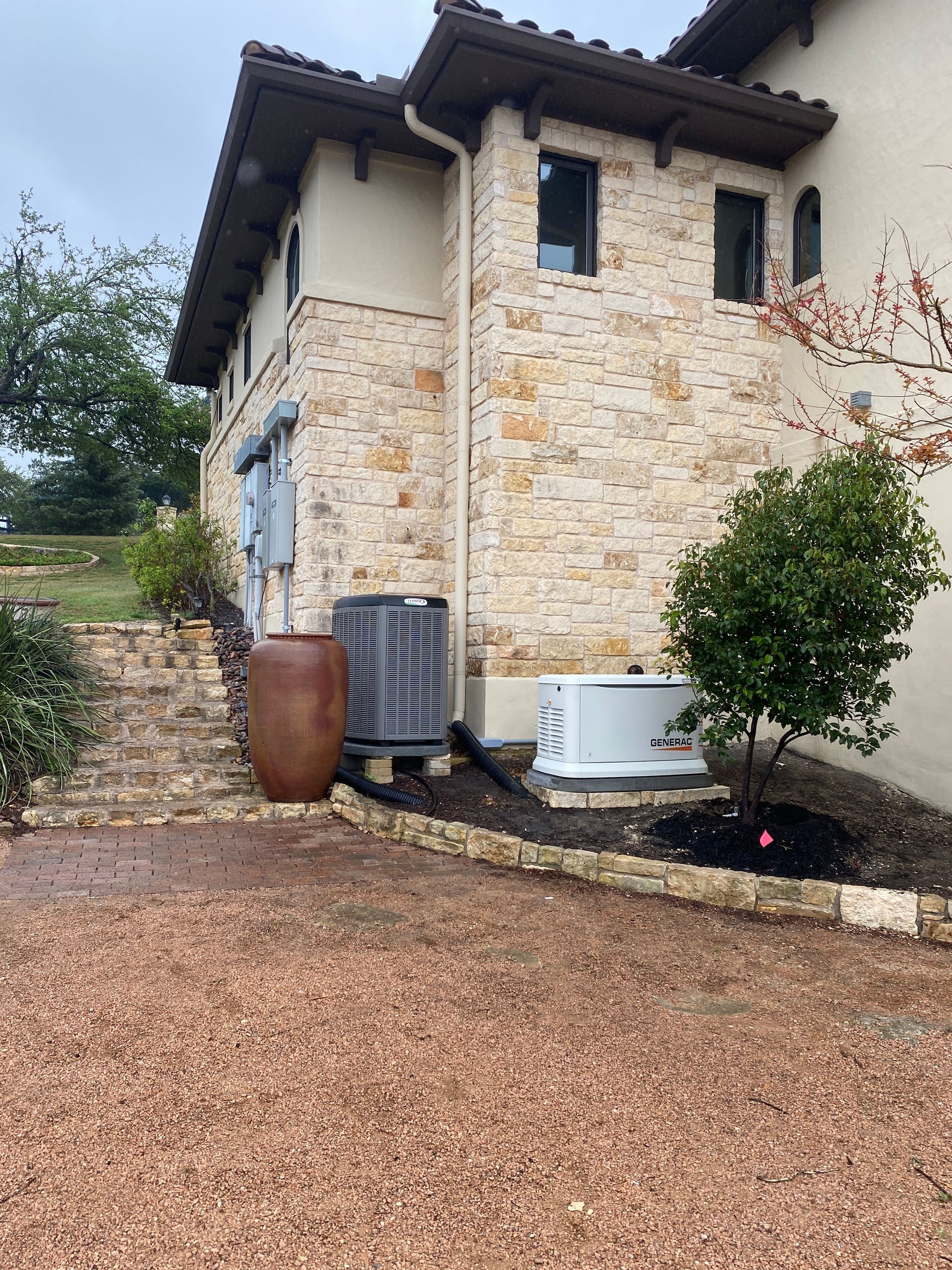A large house with a lot of plants and a generator in front of it.