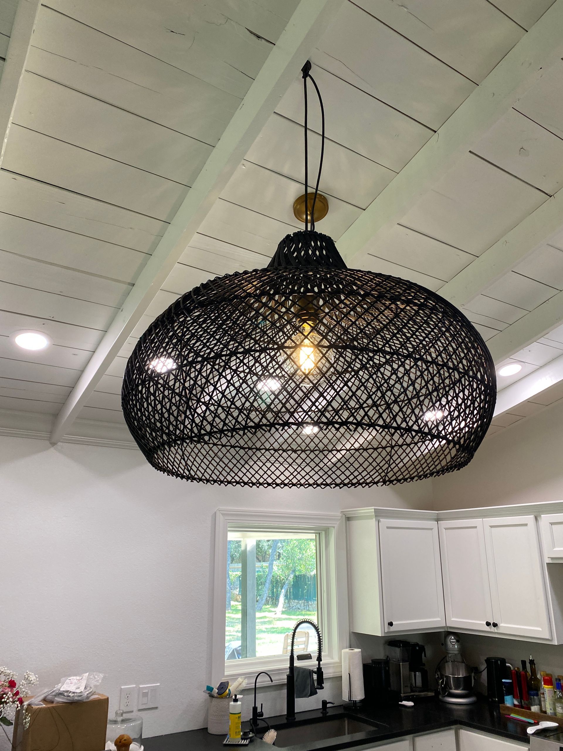 A kitchen with a large black light hanging from the ceiling