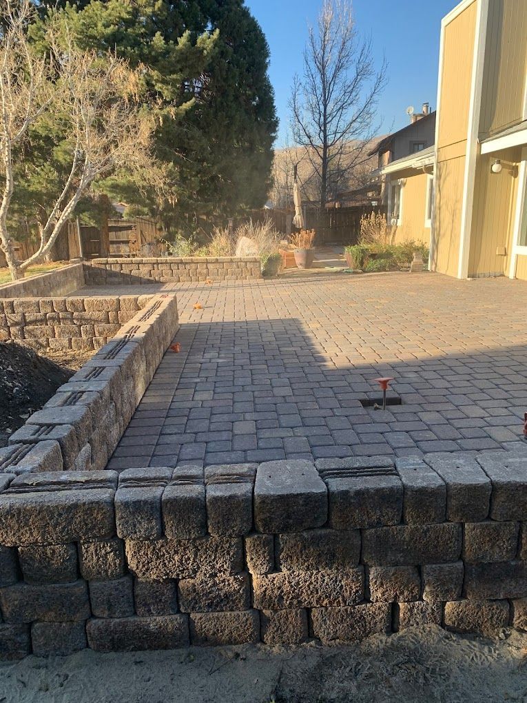 A brick wall is being built in front of a house.
