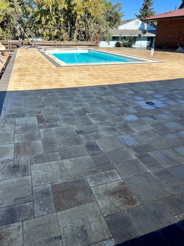 A large patio with a swimming pool in the background.