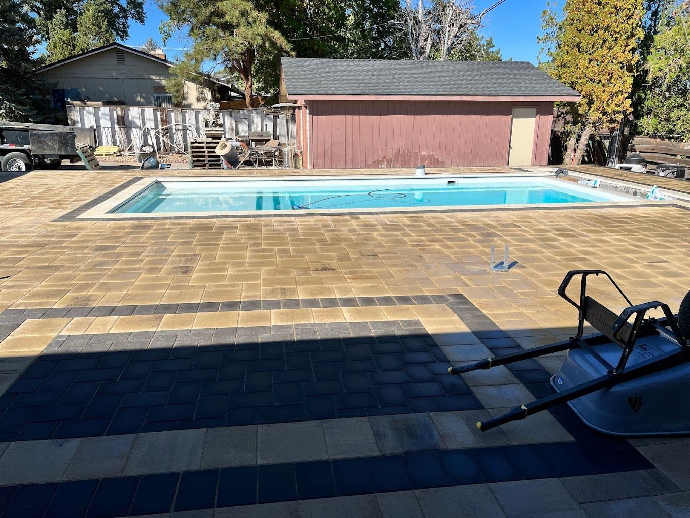 A large swimming pool is in the backyard of a house.