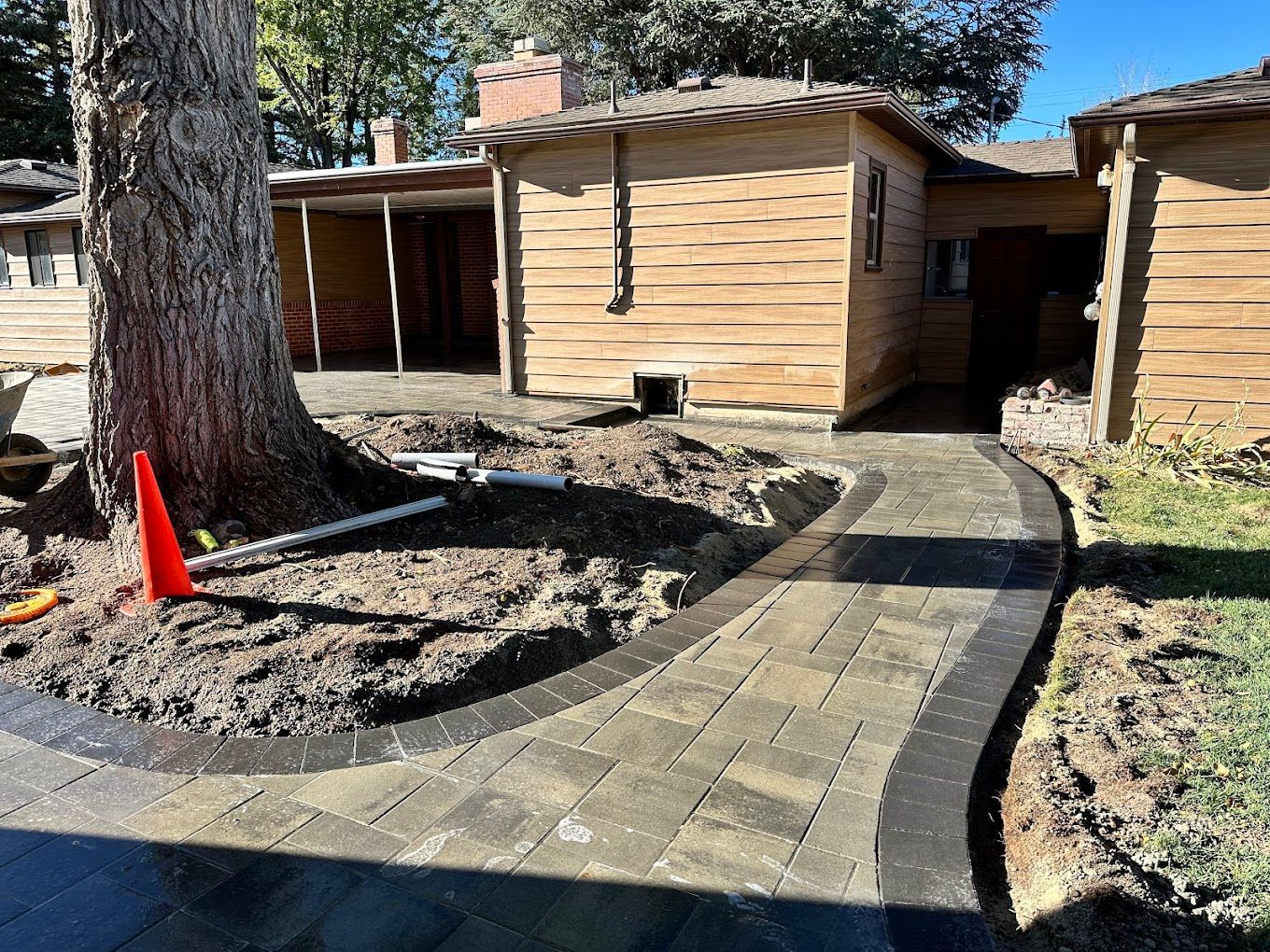 A brick walkway is being built in front of a house.
