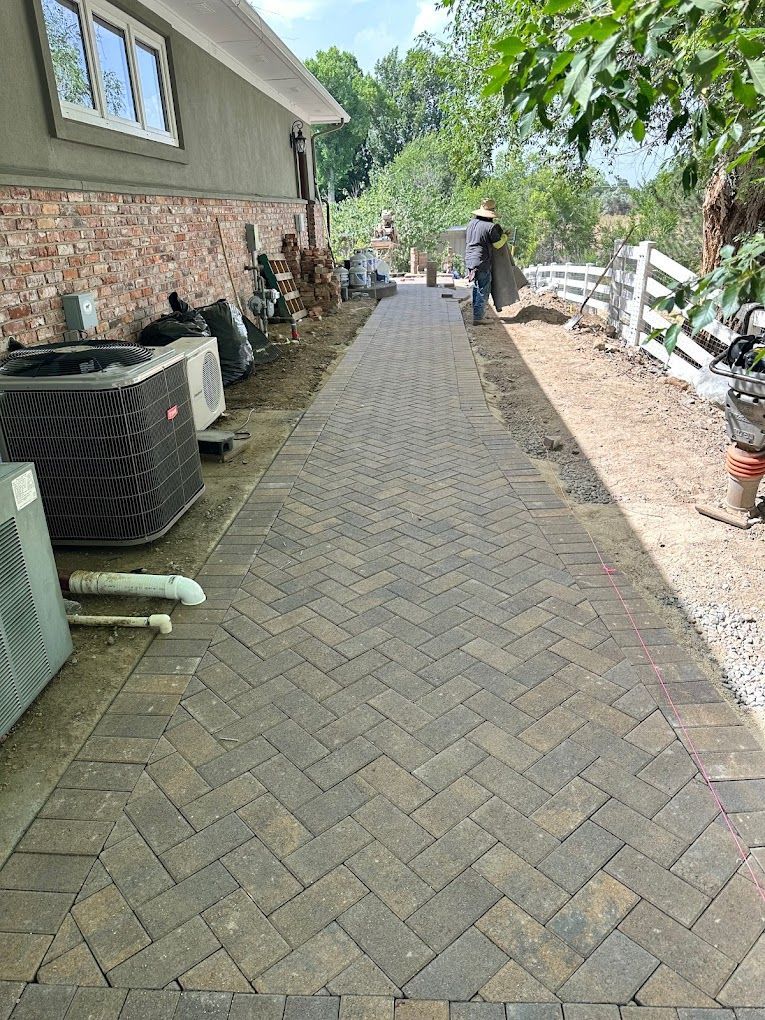 A brick walkway is being built in front of a house.