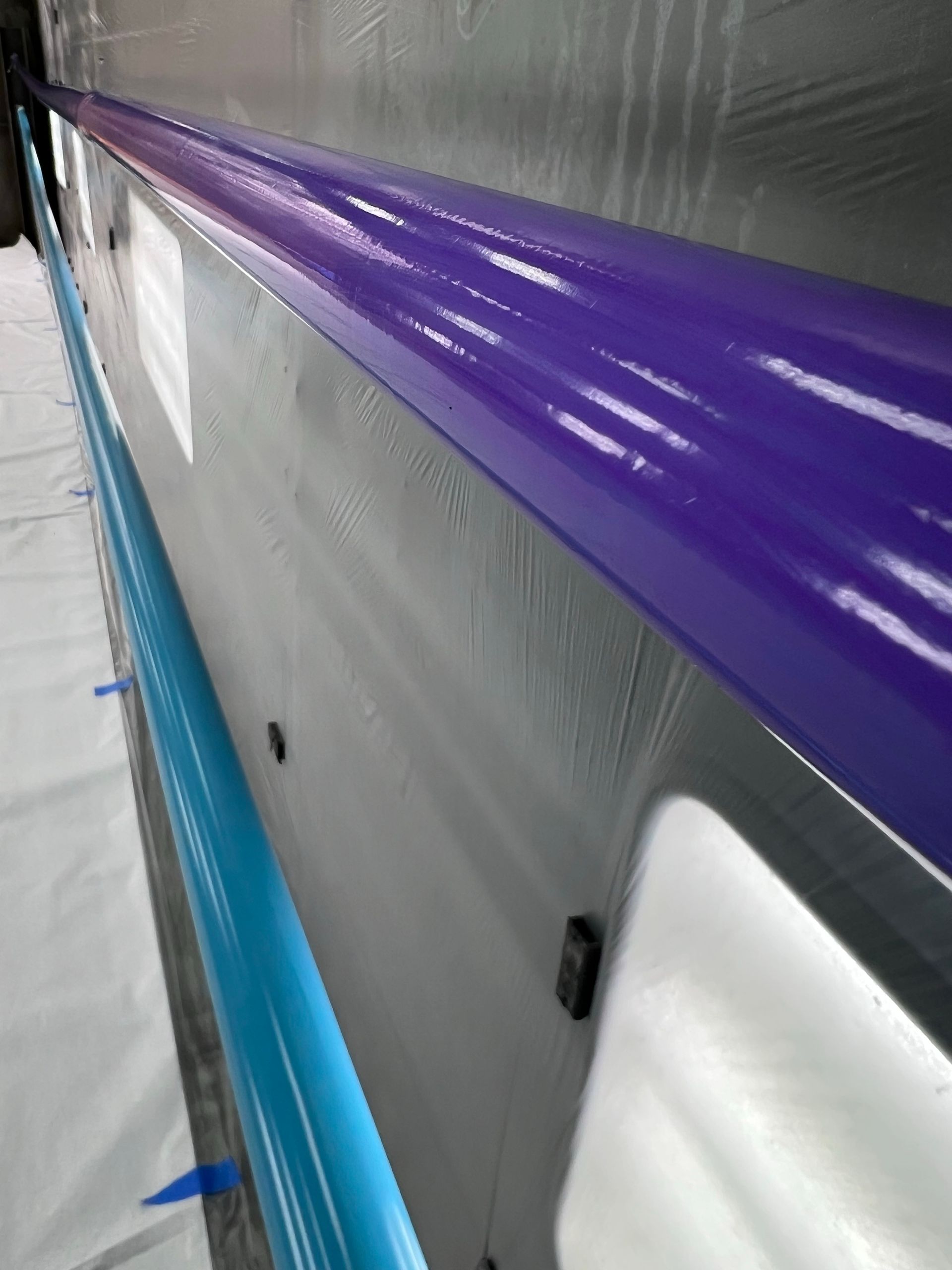 Close-up of an industrial object with a purple and blue stripe along the edge.