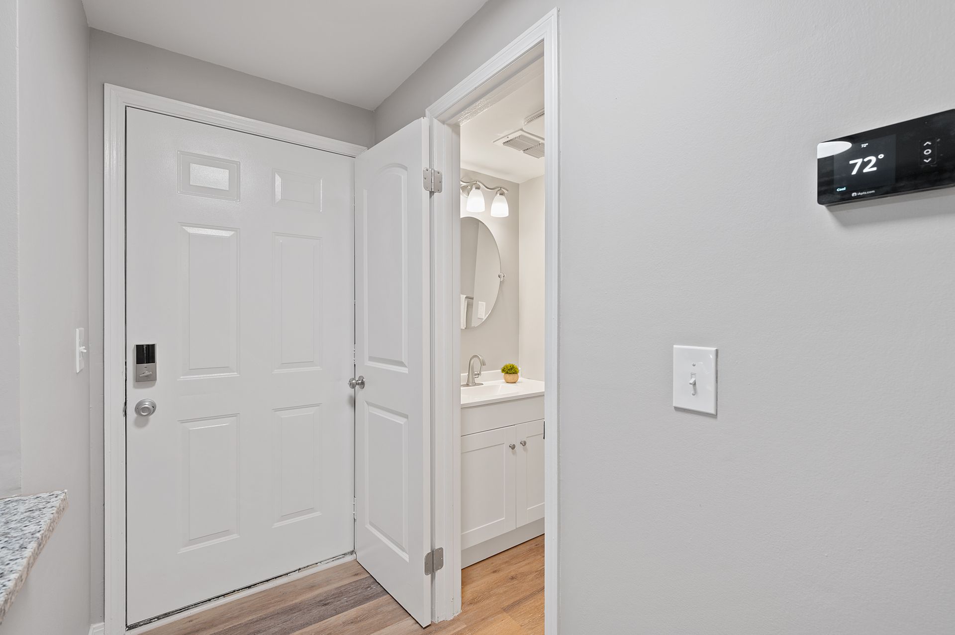 Image of the smart home thermostat and looking into the bathroom