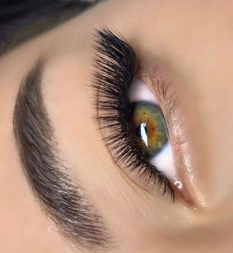 A close up of a woman 's eye with long eyelashes.