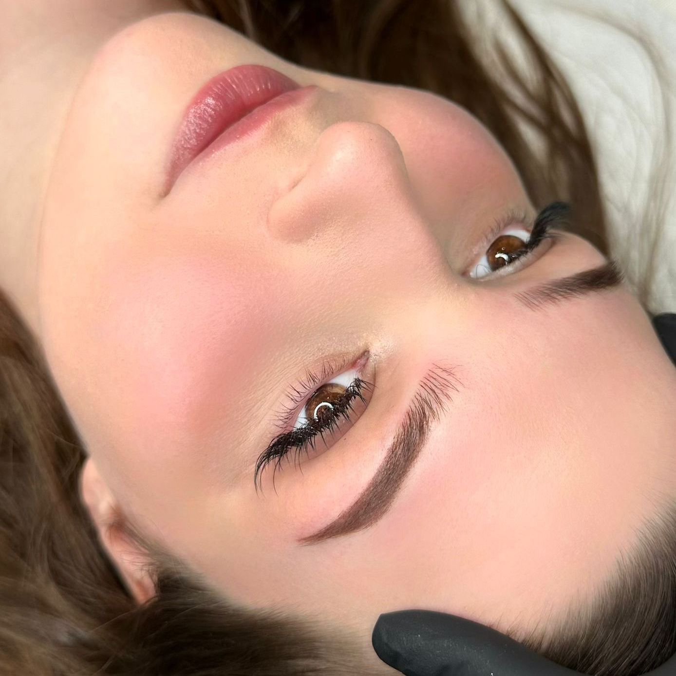 A close up of a woman 's face with a tattoo on her eyebrows.