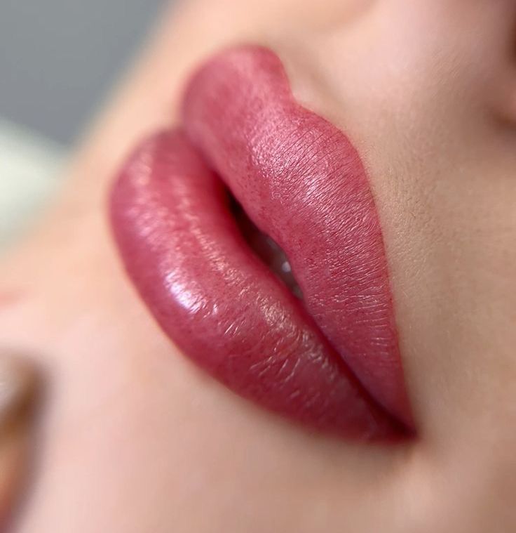 A close up of a woman 's lips with pink lipstick.