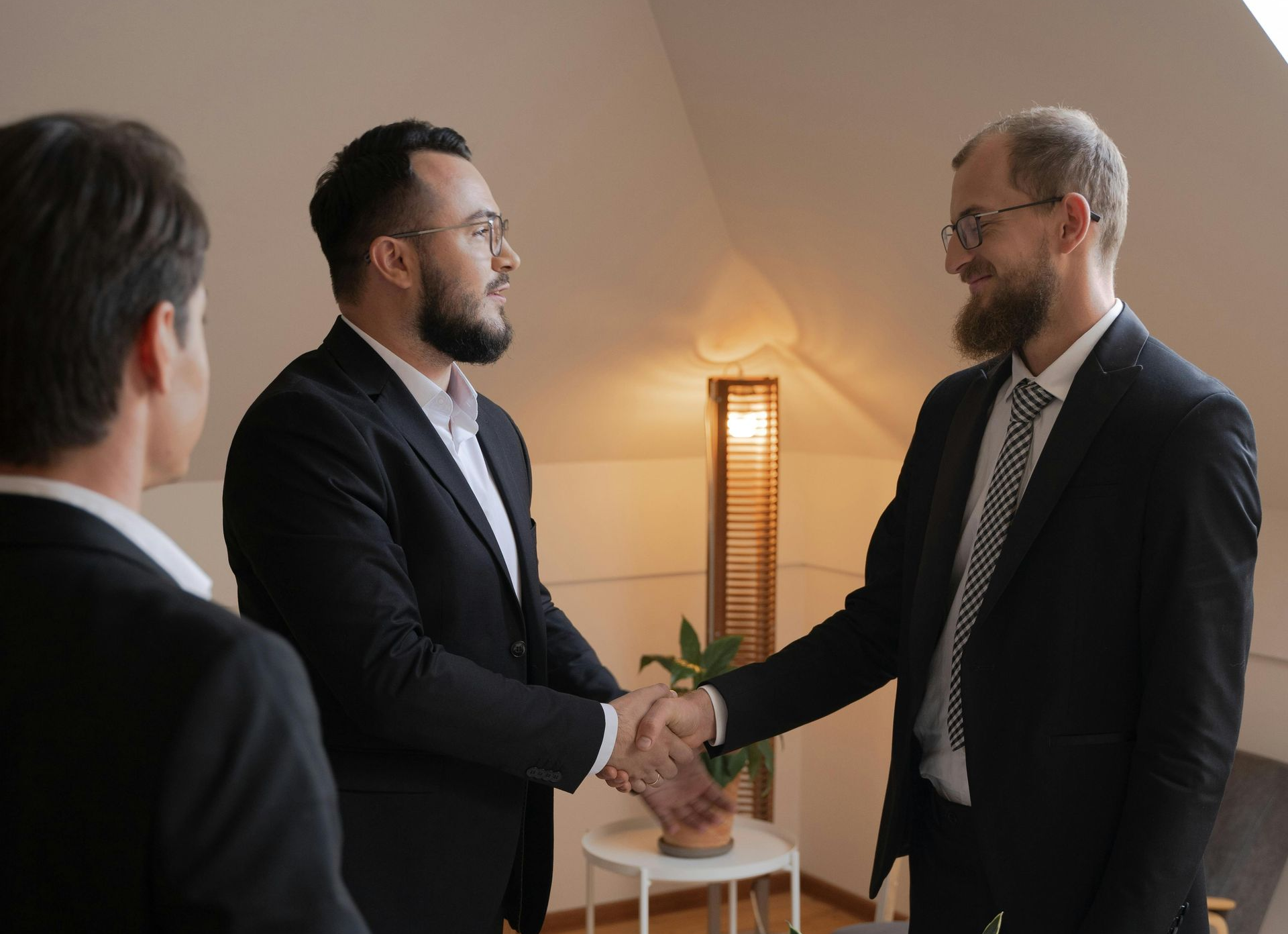 Three people are sitting at a table with a sign that says Microsoft Certified Partner on it.