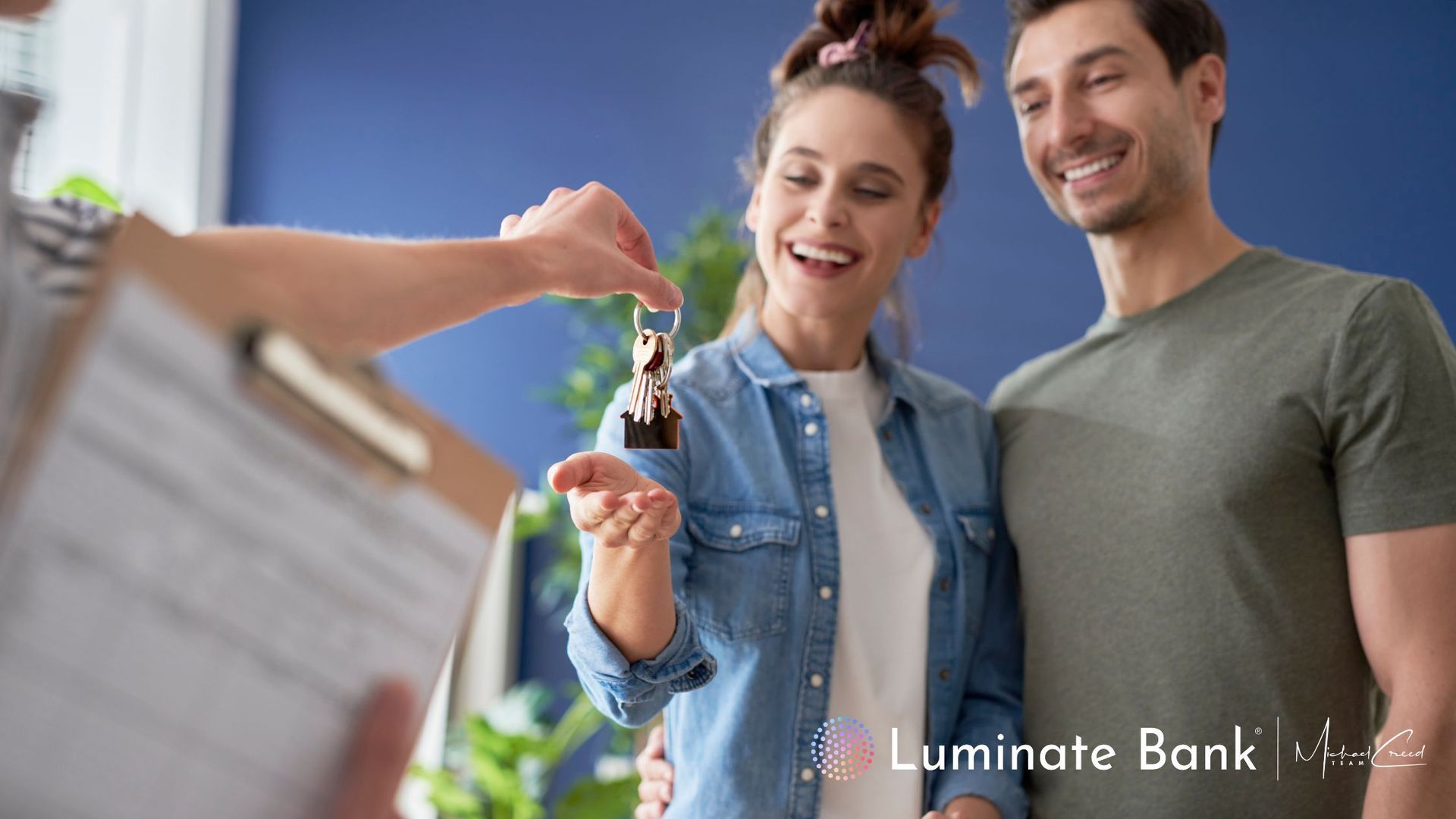 Realtor handing young couple keys to their first home. 