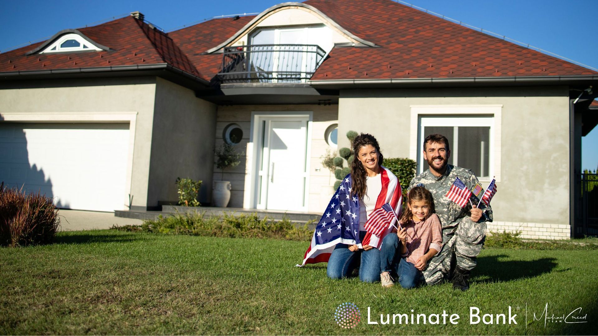 Family kneels in front of a house, wrapped in American flags, holding small flags.