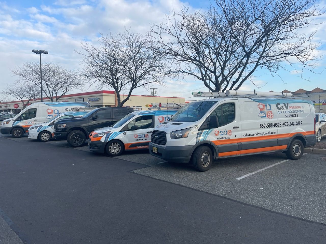 A row of vans are parked in a parking lot.