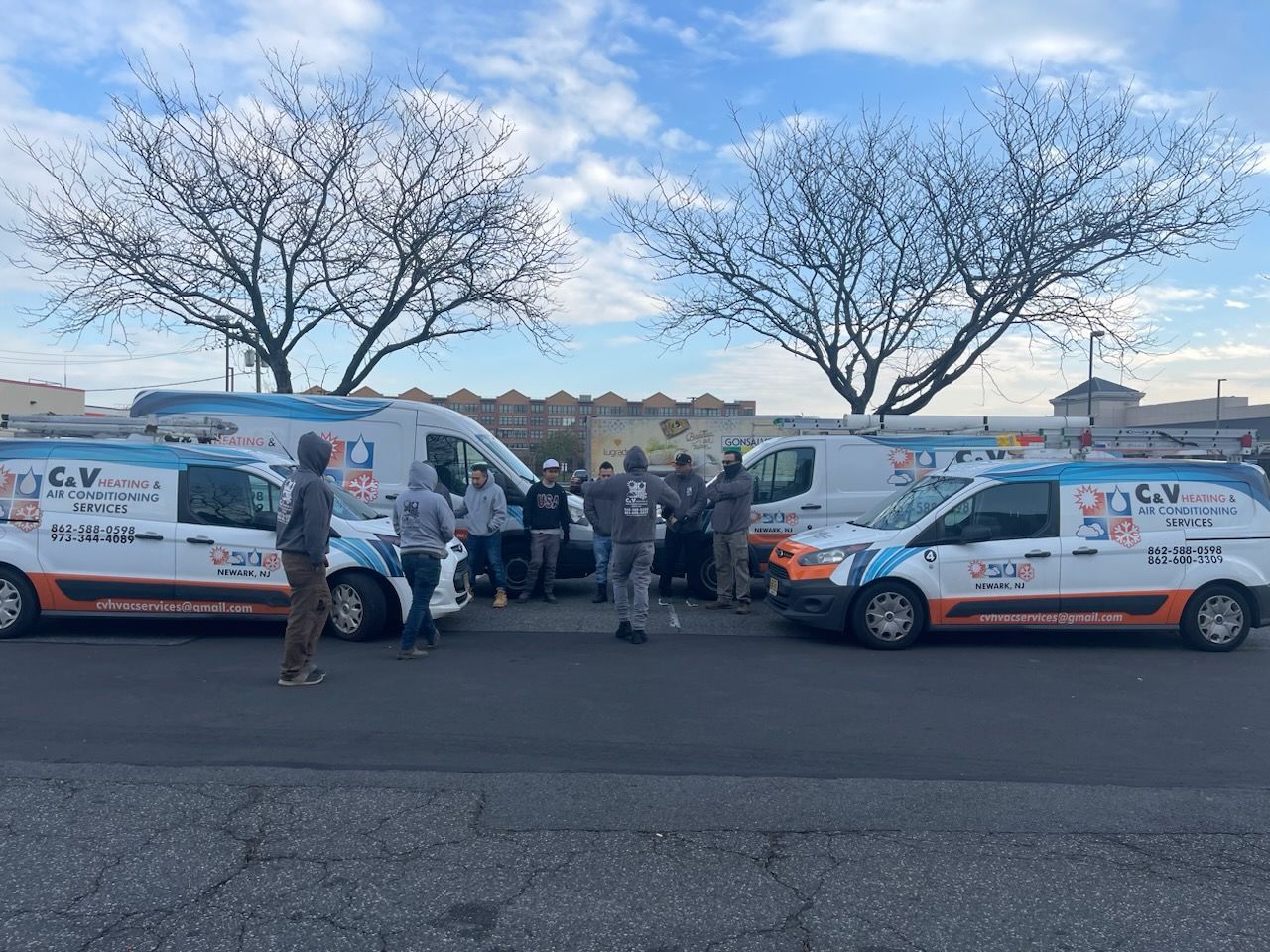 A group of people are standing in front of a row of vans.