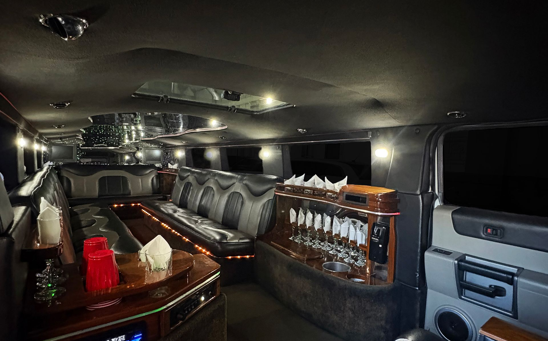 A long, silver Hummer limousine parked outdoors.