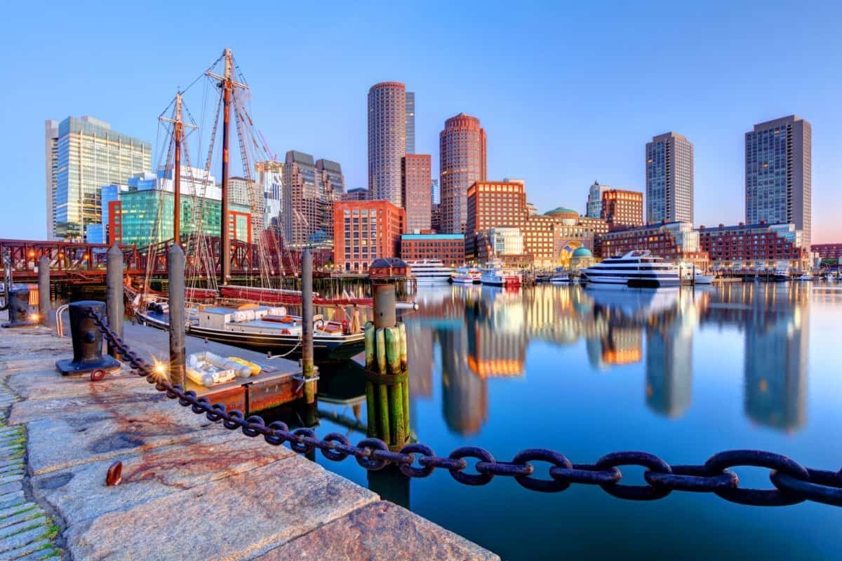 Street corner with brick buildings in Boston. Teal and red buildings under a blue sky.
