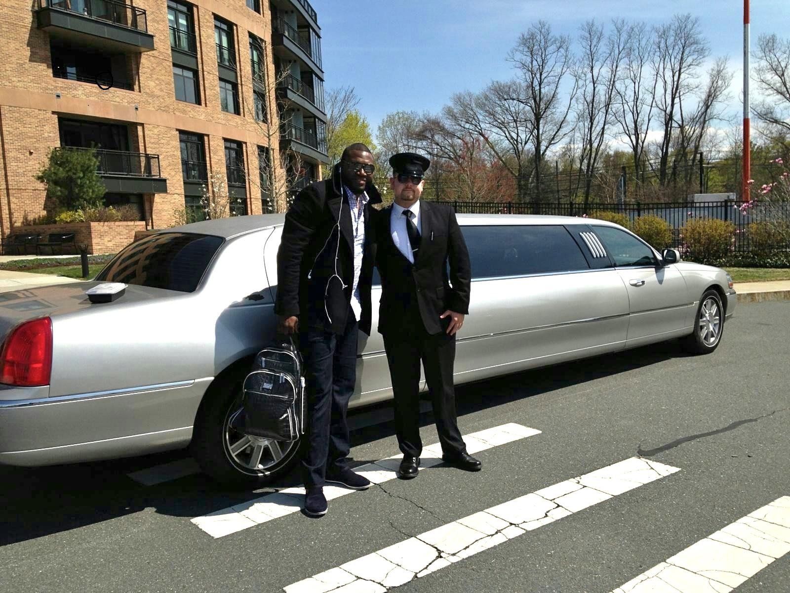 A long, silver Hummer limousine parked outdoors.