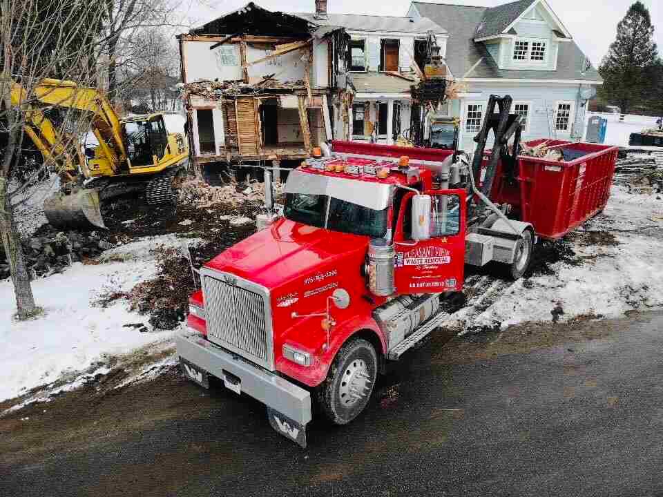 A red truck is parked in front of a house being demolished. A red truck is parked in front of a house being demolished.