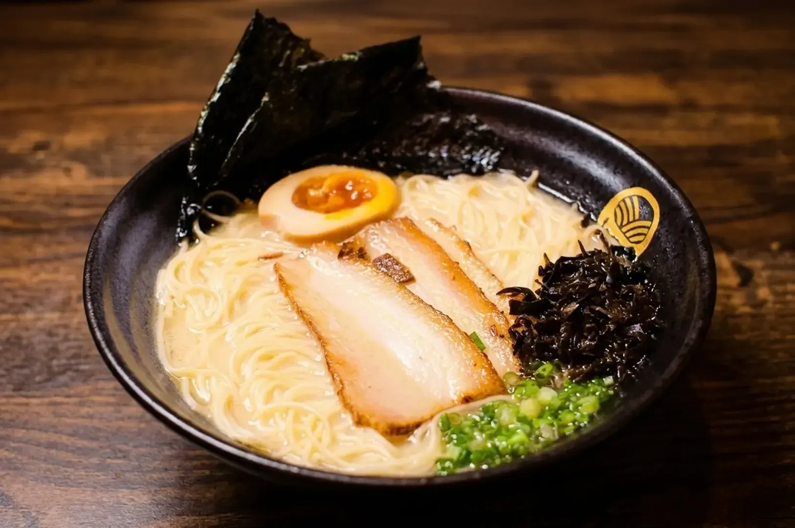 Bowl of Tonkotsu ramen featuring chashu pork, soft-boiled egg, nori, and creamy broth