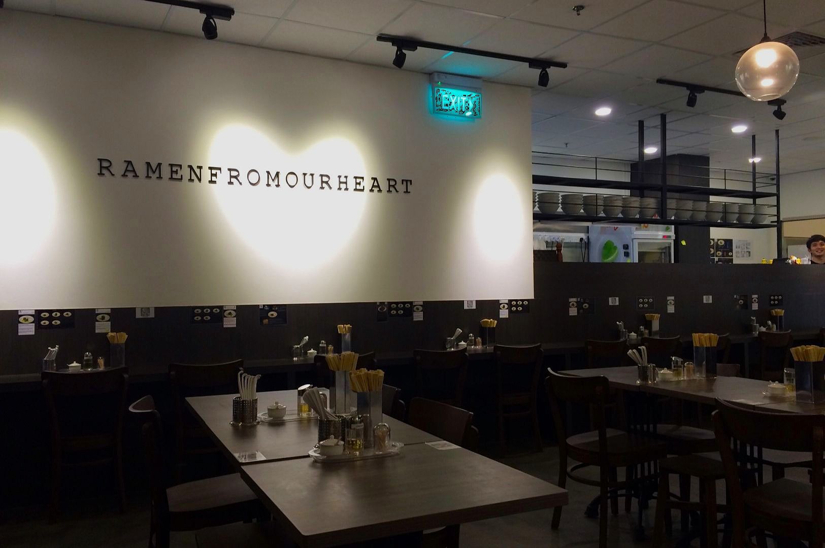 Storefront of Nanami Yakiniku, a Japanese BBQ restaurant, with a large white sign, glass entry doors, and a warmly lit interior visible through the windows.