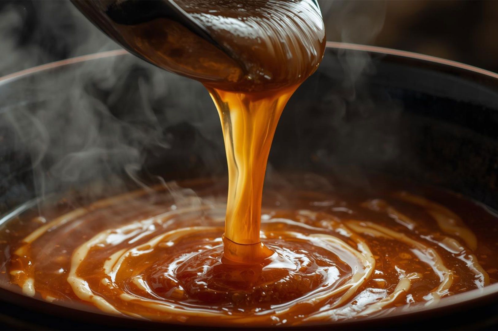 A dark, glossy, amber-colored tare or thick ramen sauce is being poured from a ladle into a steaming pot of broth, creating swirls of flavor.