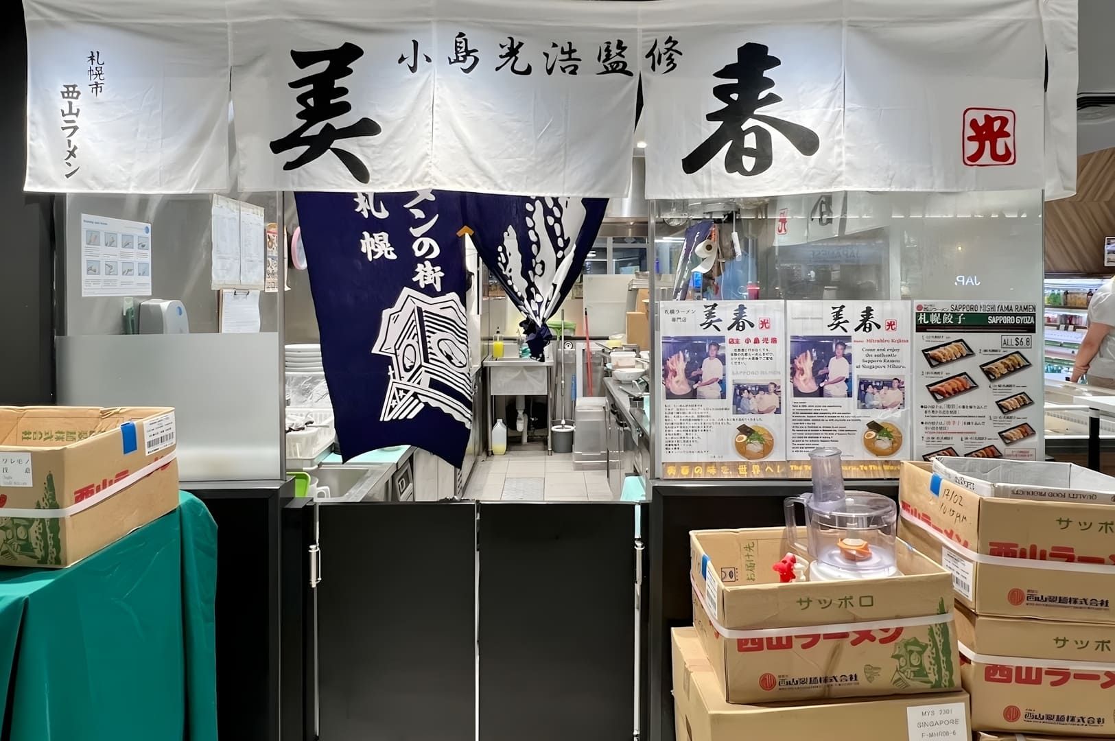 Miharu Ramen storefront with boxes outside and a sign.