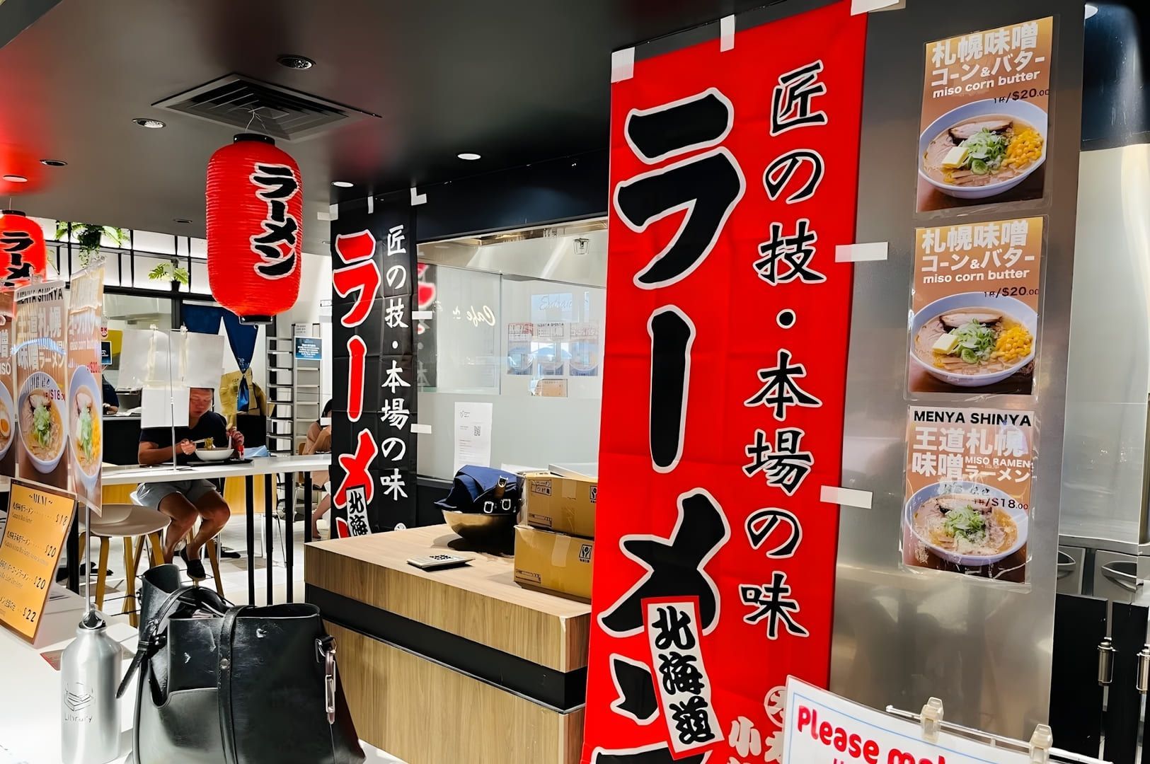 A restaurant named Miharu Ramen featuring signs and a display of various traditional Asian dishes.