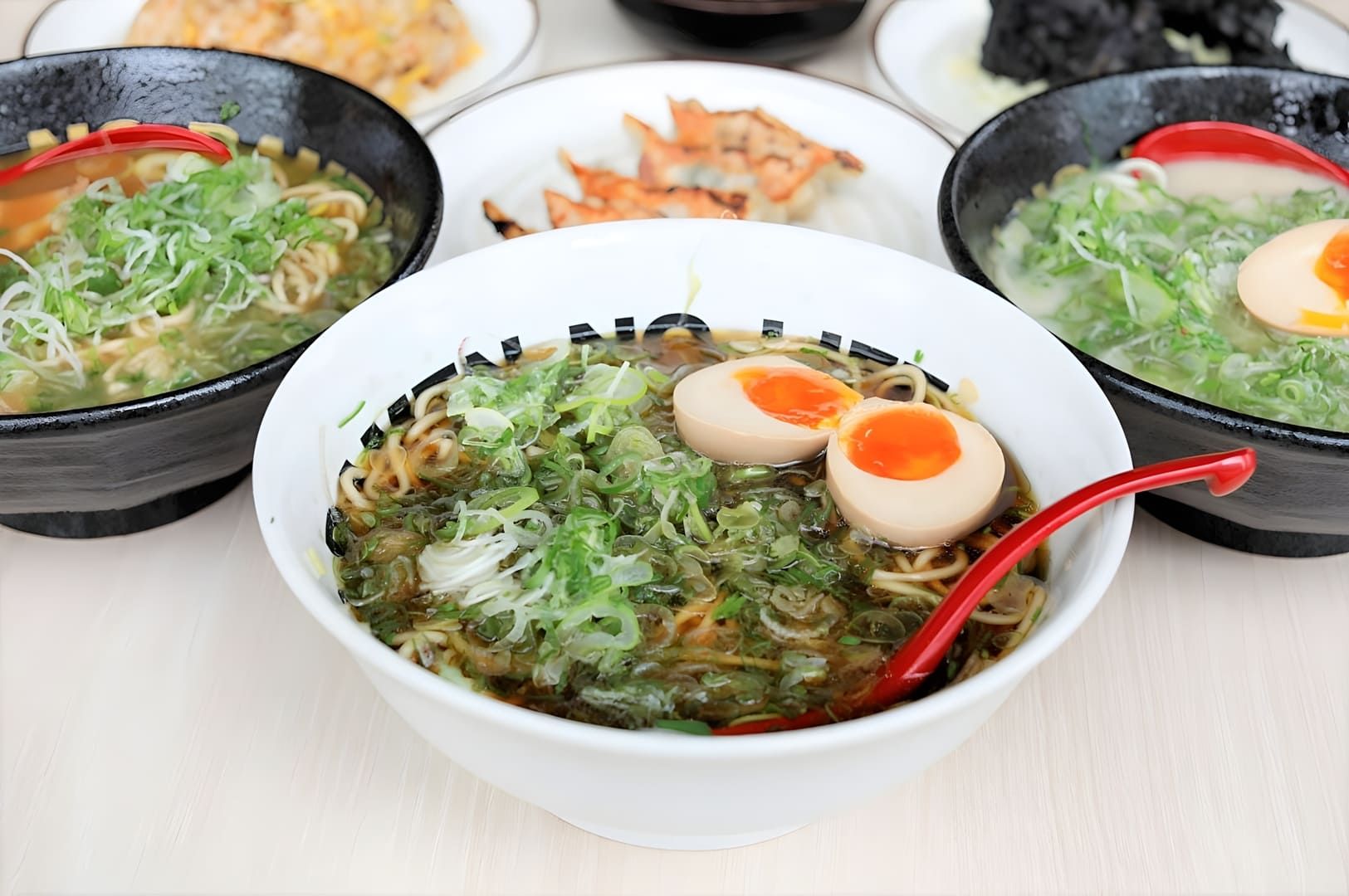 Three bowls of Singapore Vegetarian Ramen topped with eggs and fresh vegetables, showcasing a colorful and appetizing meal.