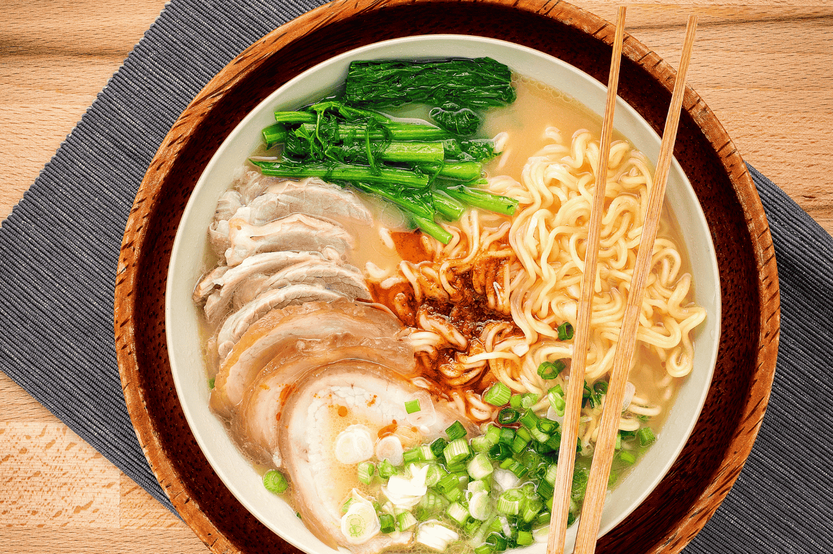 Overhead shot of a steaming bowl of ramen layered with garlic-infused broth, tender pork slices.